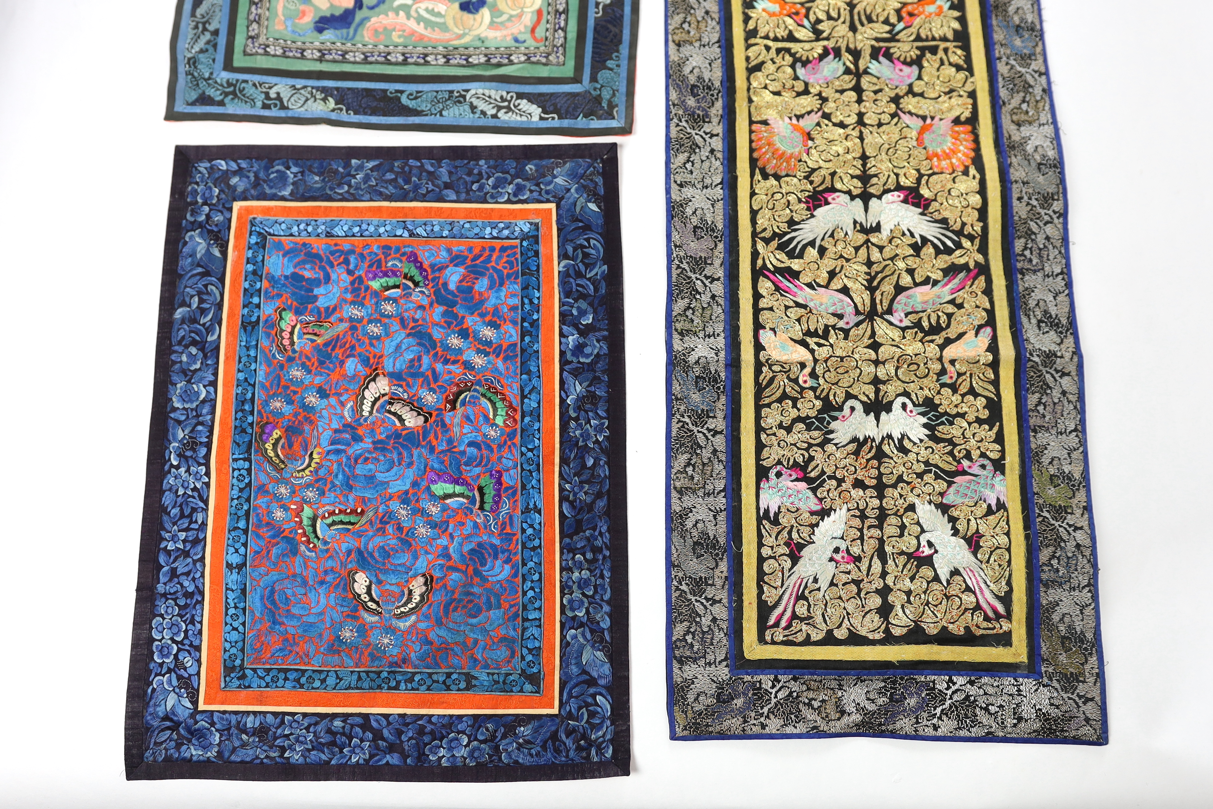 Five Chinese late Qing dynasty silk embroidered panels, two being embroidered with Beijing knot, a pair of metallic embroidered with phoenix sleeve bands, the other embroidered with butterflies and flowers, all five pane